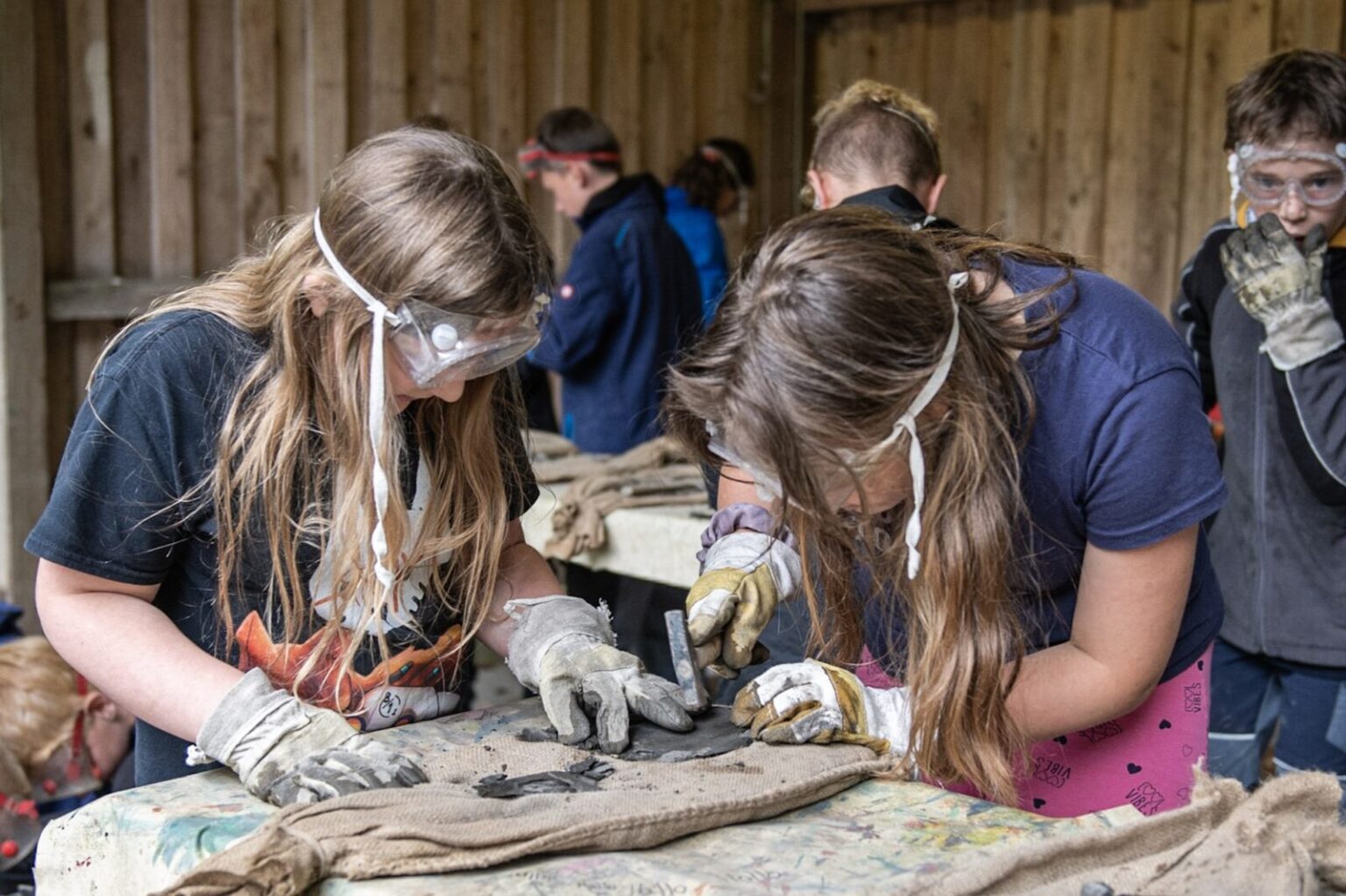 Zwei Mädchen verfeinern gerade am Tisch ihren Fossilienfund