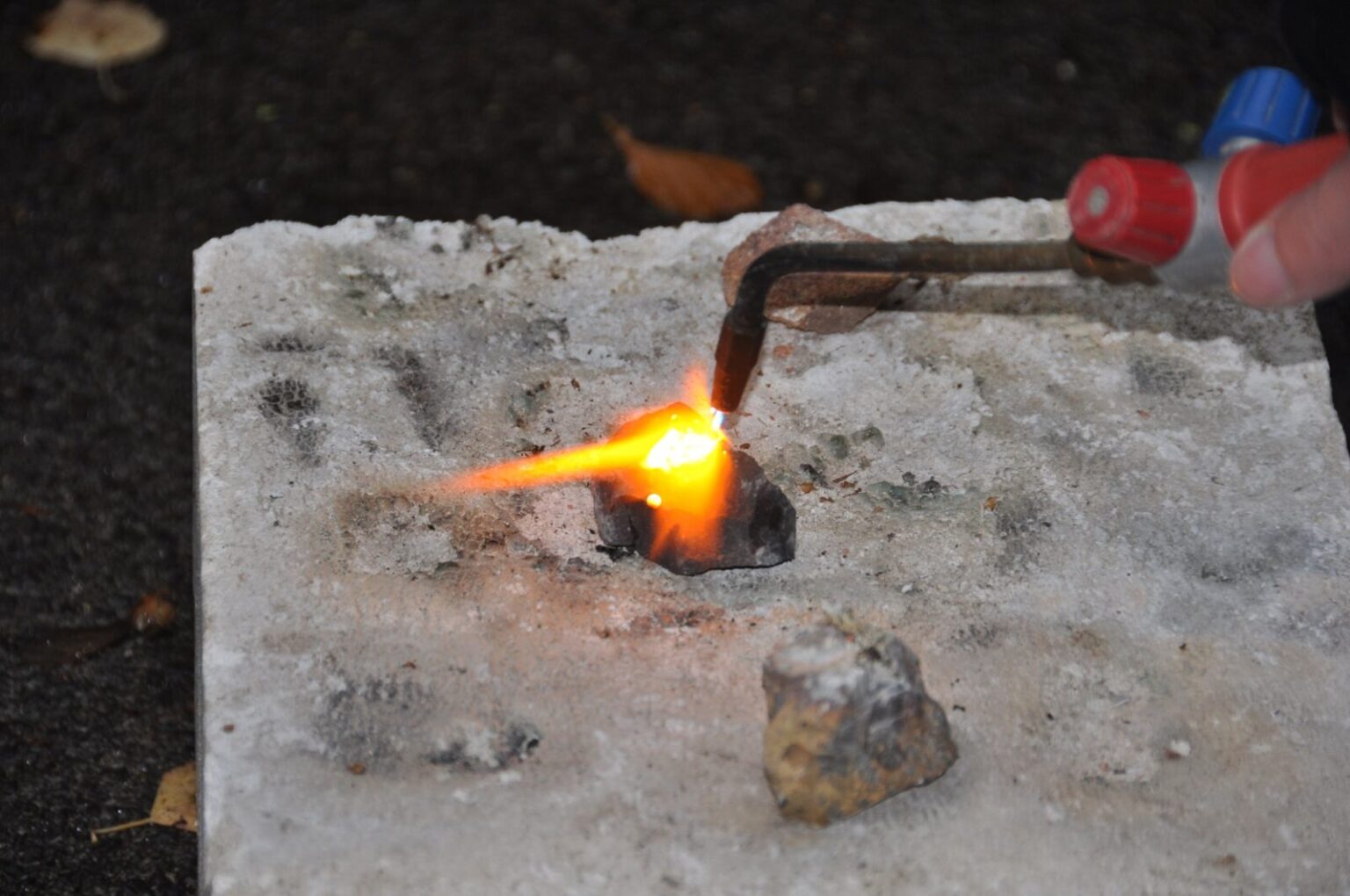 Ein Stück Basalt wird mit dem Schweißbrenner aufgeschmolzen