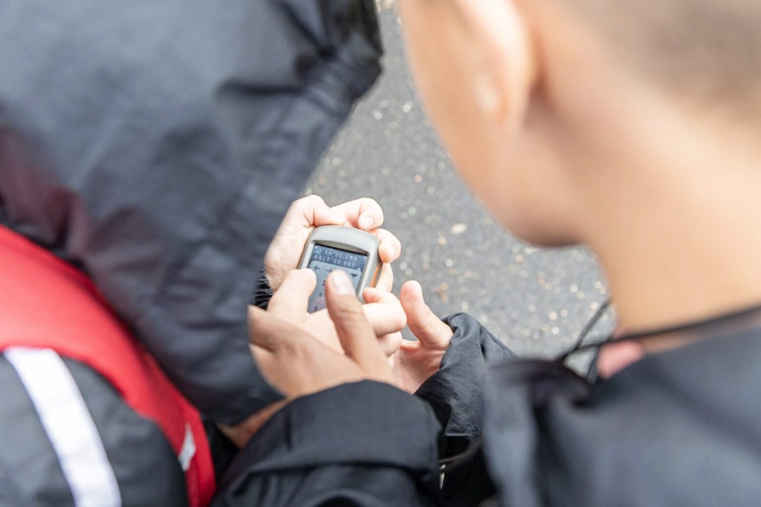 Zwei Jungen geben die Koordinaten in ein GPS-Gerät ein