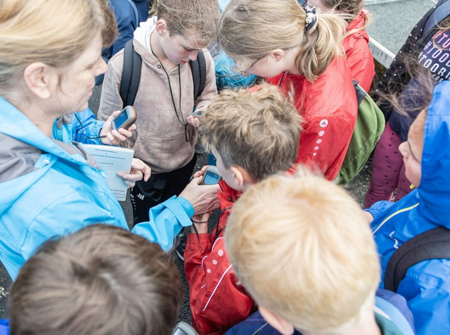 Die Leitung des Studienhauses unterweist Kinder in Gebrauch von GPS-Geräten