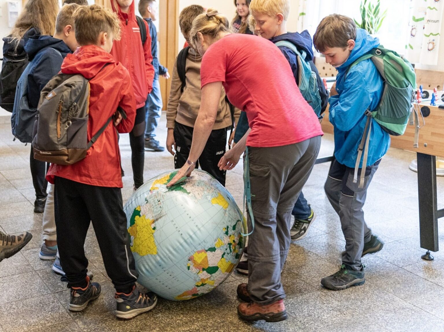 Die Leitung vom Studienhaus erklärt anhand eines Wasserglobus die Längen- und Breitengrade