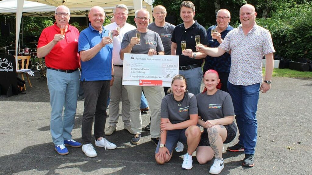 Foto: Sabine Pagel | Mit einem Glas Apfelsecco wurde auf den Fortbestand des Bauersberg angestoßen (von links): Georg Straub (Vorstandsvorsitzender Sparkasse Bad Neustadt), Landrat Thomas Habermann, Klaus Grenzer (Vorstandsvorsitzender Sparkasse Bad Neustadt), Geschäftsführer Markus Seibel, Einrichtungsleiter Dieter Köstler, Staatssekretär Sandro Kirchner, Hubert Götz (Landesvorsitzender Bayerischen Schullandheimwerk), Georg Seiffert (Bürgermeister Bischofsheim) und (vorne von links) Maria Herrmann und Jacqueline Vogt stellvertretend für die Mitarbeiter des Bauersberg.